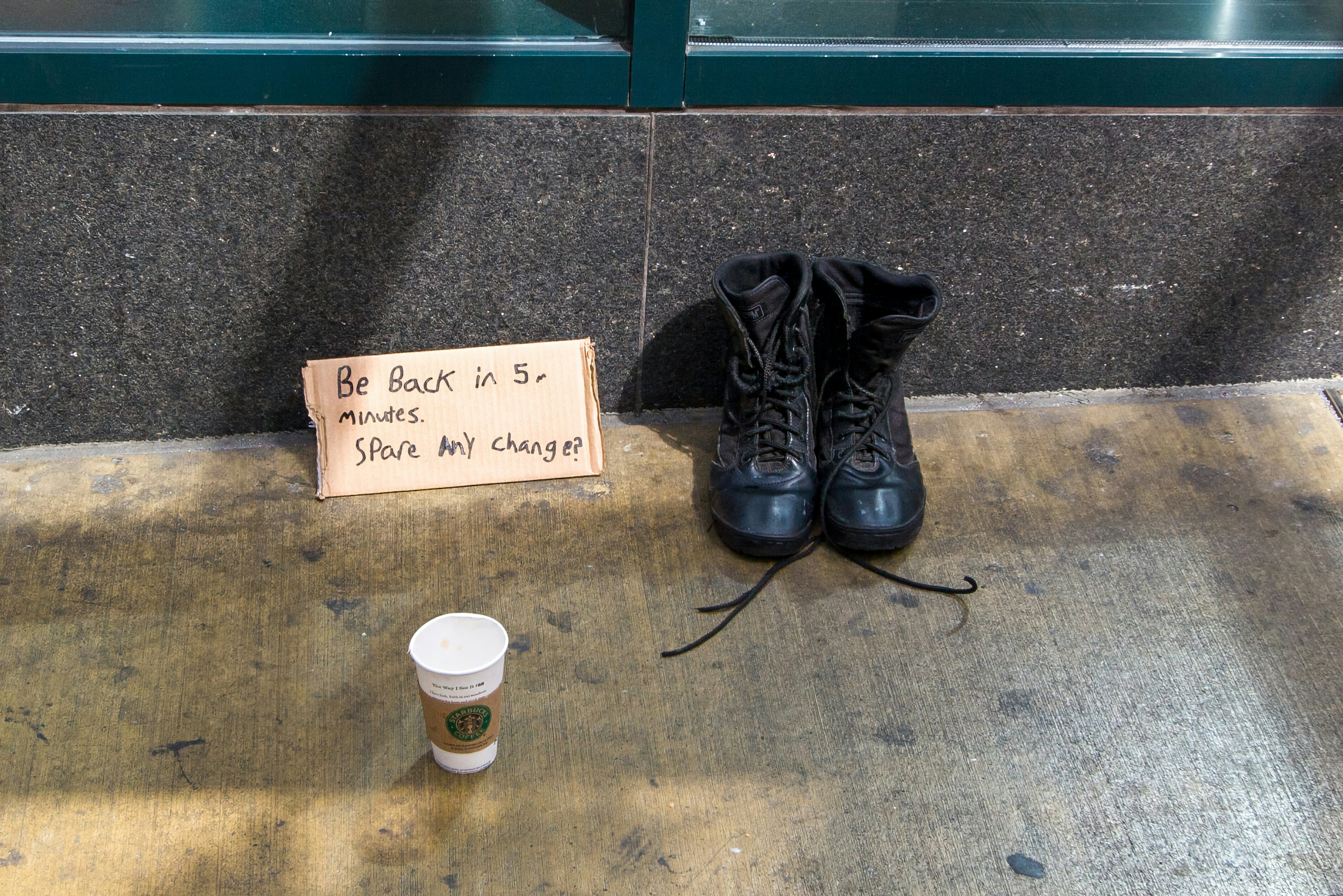 black leather boots beside white and black coffee cup